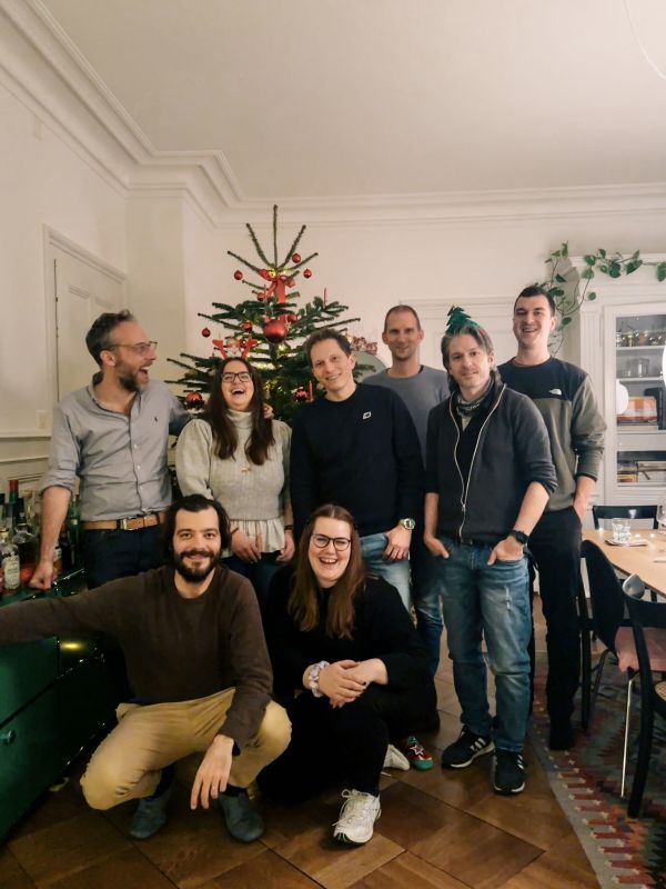Das Team von Helga im Wohnzimmer vor einem geschmückte Weihnachtsbaum